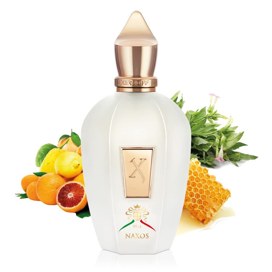 Perfume bottle with fruit, honey, and greenery on a white background