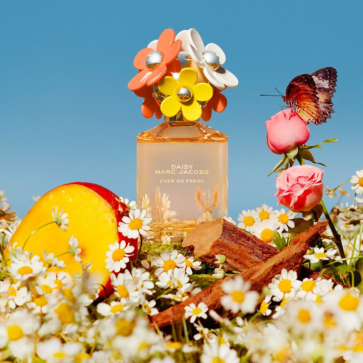Marc Jacobs Daisy perfume bottle surrounded by flowers and a butterfly against a blue sky.