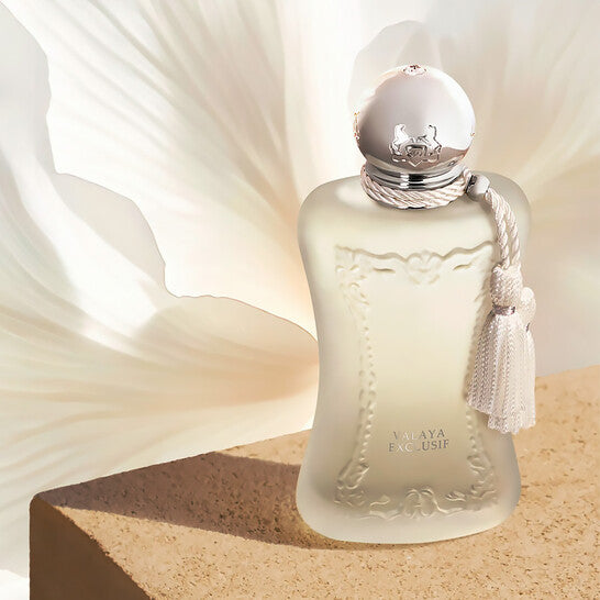 Perfume bottle with silver cap and decorative elements on a beige background