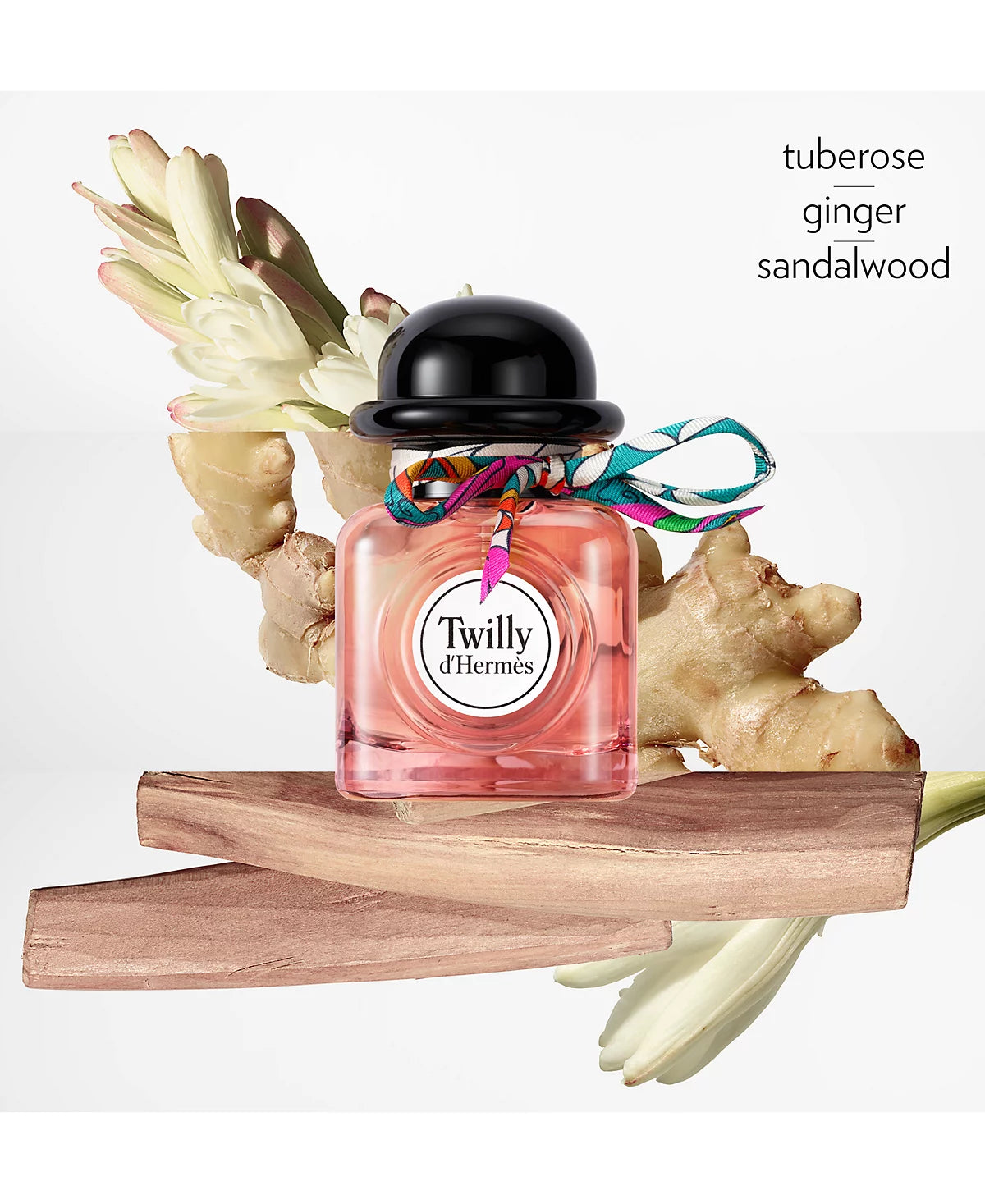 Perfume bottle with floral elements and 'Twilly d'Hermes' branding on a white background