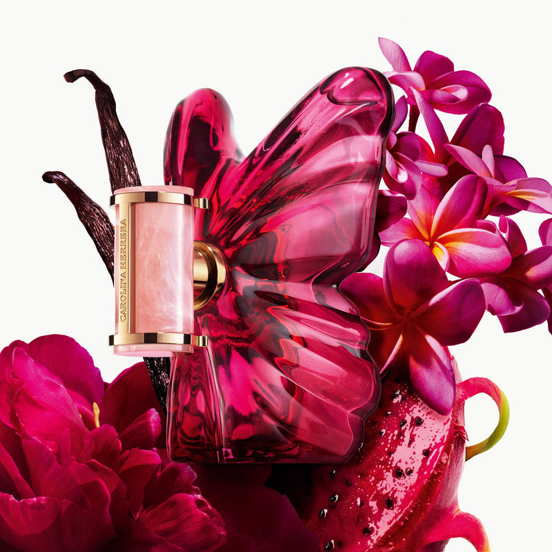 Pink butterfly-shaped perfume bottle with flowers on a white background