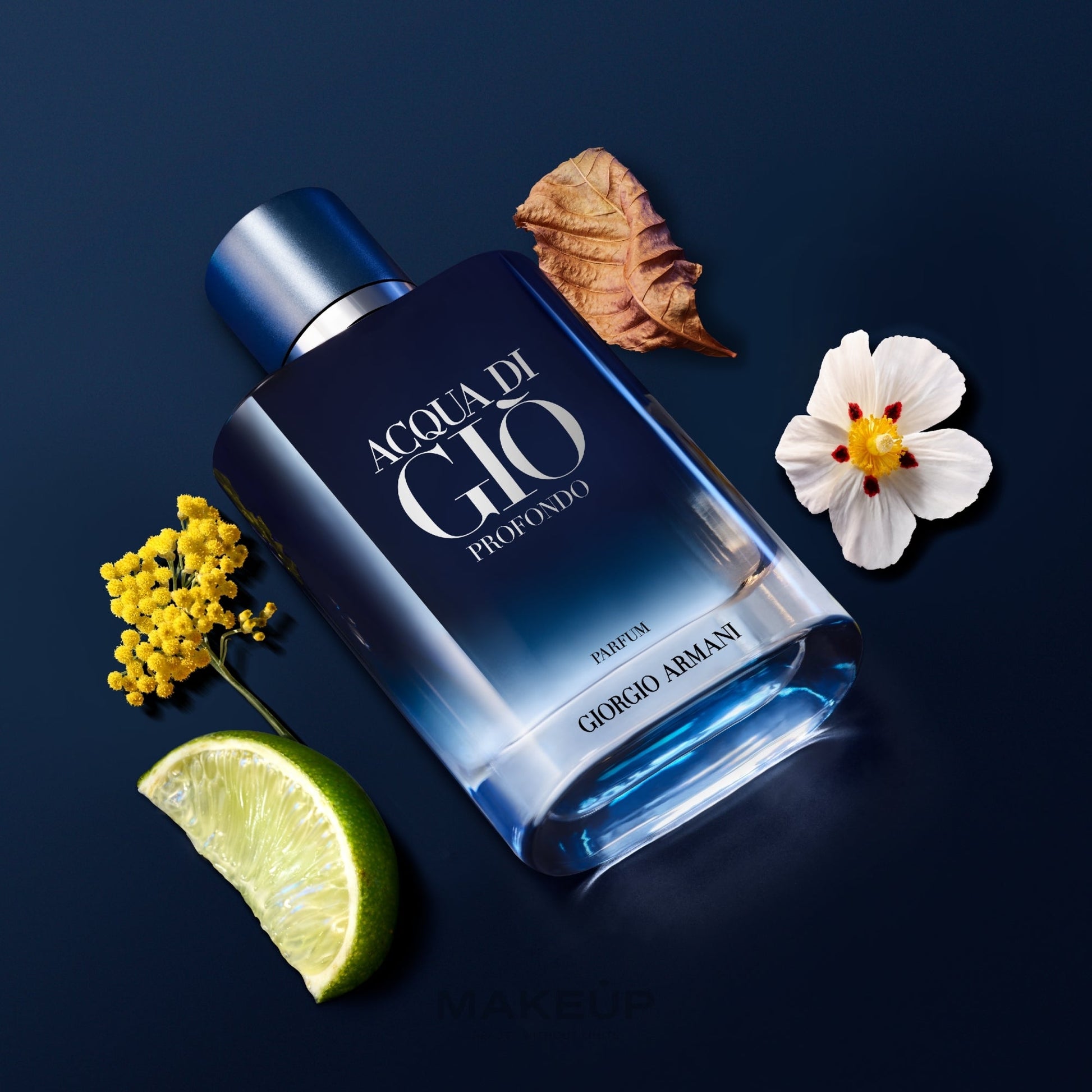 Giorgio Armani Acqua di Giò Profondo perfume bottle with flowers and a lime wedge on a dark background