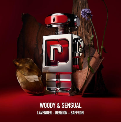 A perfume bottle with a metallic silver and red robot-like design, styled with a dark red background, wood props, a crystal, and a purple flower. Text at the bottom reads 'WOODY & SENSUAL', 'LAVENDER - BENZON - SAFFRON'.