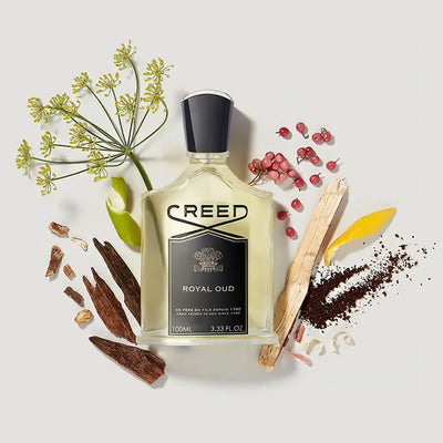Creed Royal Oud perfume bottle surrounded by natural elements on a light background