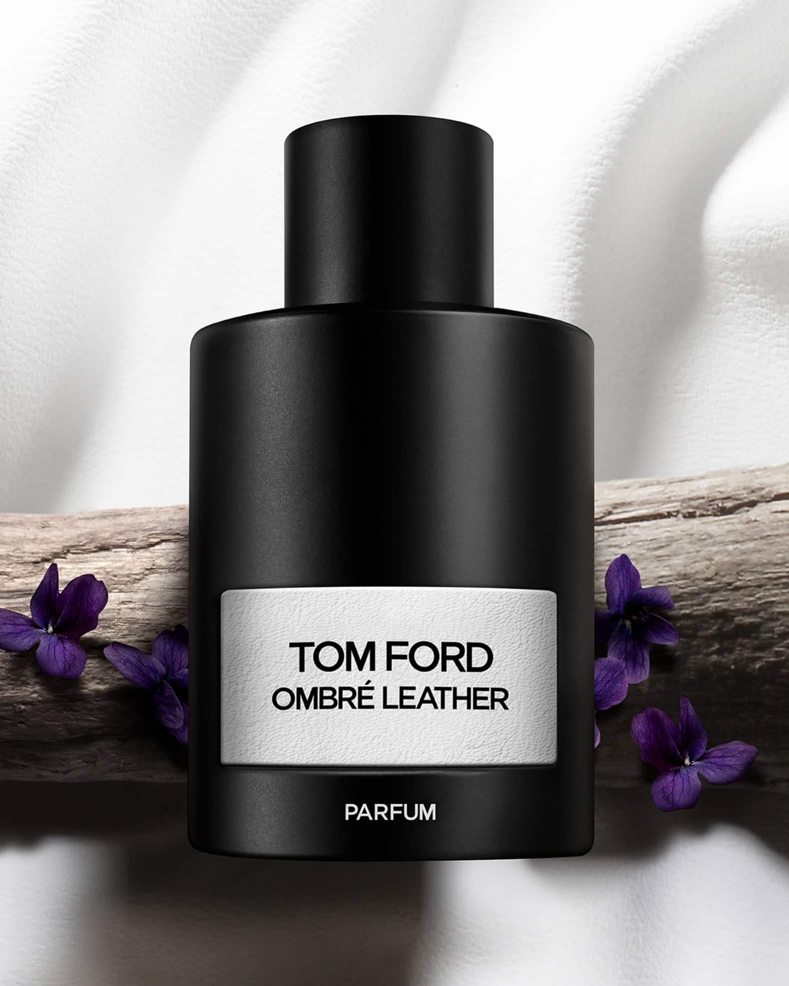 Tom Ford Ombre Leather parfum bottle with purple flowers on a white background